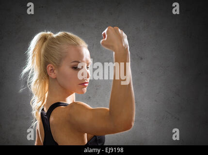sporty woman from the back flexing her biceps Stock Photo
