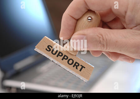 support marked on rubber stamp in hand Stock Photo