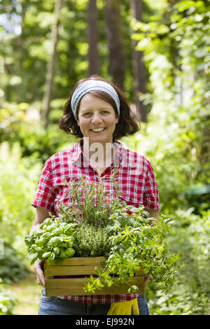 woman with herbs in a garden Stock Photo