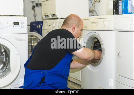 Technician repairing a washing machine Stock Photo