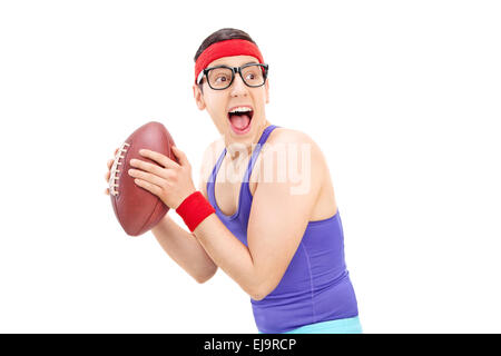 Young nerdy guy in sportswear playing football isolated on white background Stock Photo