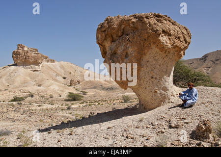 Omani man with desert mushroom near Mazara, Oman Stock Photo