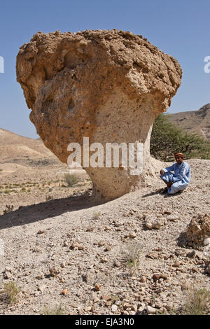 Omani man with desert mushroom near Mazara, Oman Stock Photo