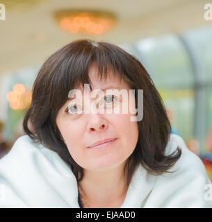 middle-aged woman brown eyes is sitting in the apartment Stock Photo