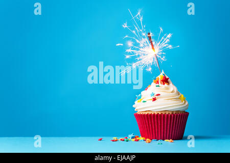 Cupcake with sparkler against a blue background Stock Photo