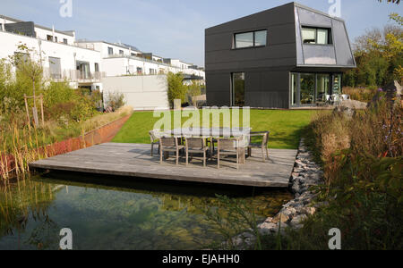Pond with wooden deck and modern house Stock Photo