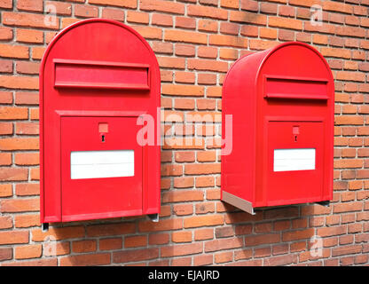 Red mail boxes on brick wall Stock Photo