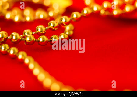 Gold beads on red fabric. macro shooting Stock Photo