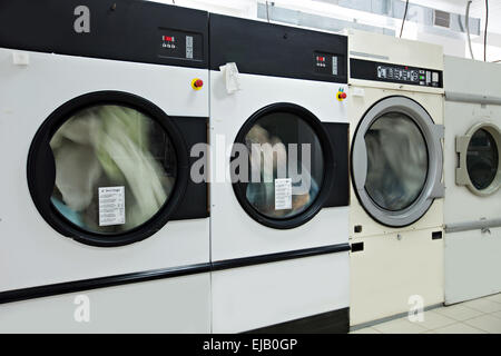 Running washing machines in laundry room Stock Photo