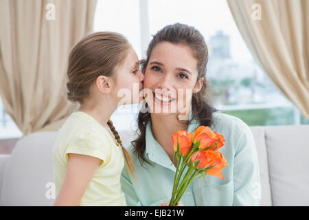 Cute girl giving flowers to mother Stock Photo