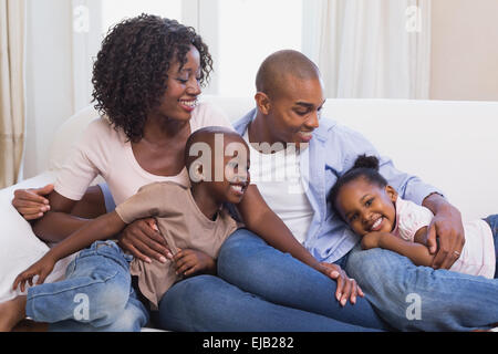 Happy family posing on the couch together Stock Photo