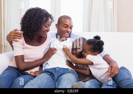 Happy family sitting on the couch together Stock Photo