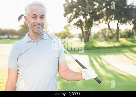 Smiling handsome golfer looking at camera Stock Photo