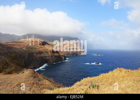 Windmills on abrupt coast of ocean Stock Photo