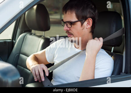 Male european driver is using seat belt in a car