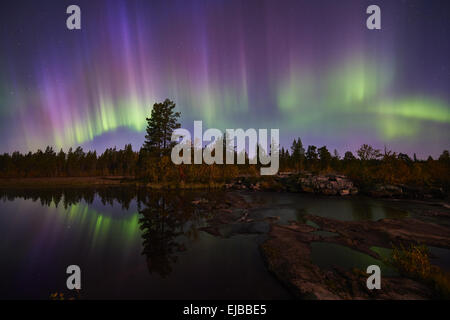 Northern lights reflecting in a lake, Lapland Stock Photo