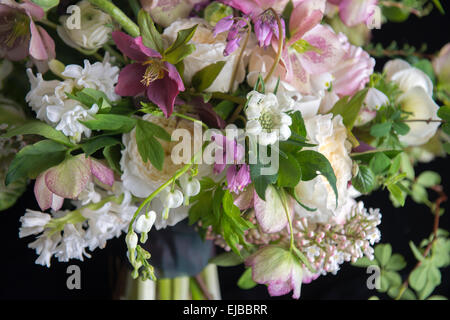 Abundant floral bouquet of spring blooming flowers including ranunculus hellebore parrot tulip tulipa and white Bleeding Heart Stock Photo
