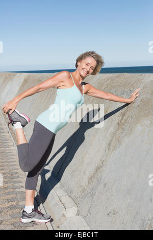 Active senior woman stretching on the pier Stock Photo