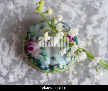 Lily of the Valley flowers (Convallaria majalis) with hand painted lid of bowl Stock Photo