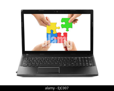 Hands and puzzle in computer notebook Stock Photo