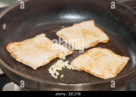 fry the meat in a frying pan Stock Photo