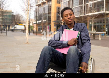 young disabled student sitting in a wheelchair  holding folders Stock Photo