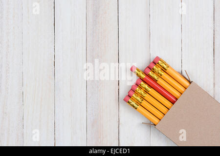 A box of yellow pencils with one red pencil partially pulled out. The plain brown box is in the lower right corner of the frame