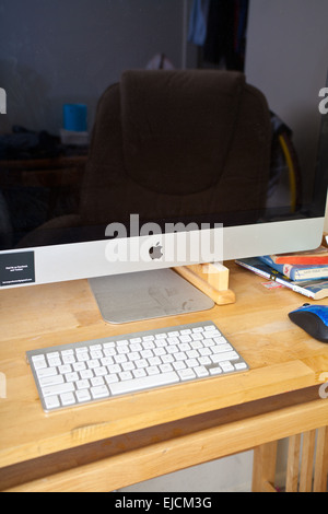 A male college students desk with Imac computer, Ipod, and a copy of John Steinbecks The Grapes of Wrath Stock Photo