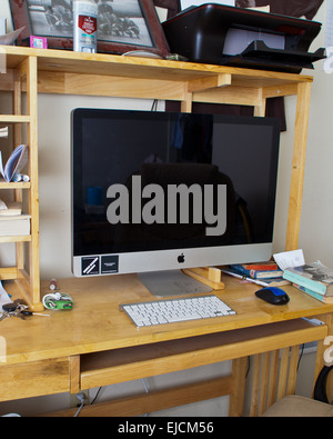 A male college students desk with Imac computer, Ipod, and a copy of John Steinbecks The Grapes of Wrath Stock Photo