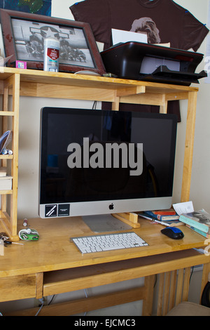A male college students desk with Imac computer, Ipod, and a copy of John Steinbecks The Grapes of Wrath Stock Photo