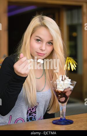 Young pretty girl eating chocolate ice cream Stock Photo