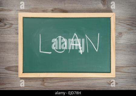 Handwriting loan letter on chalkboard, wooden background. Stock Photo