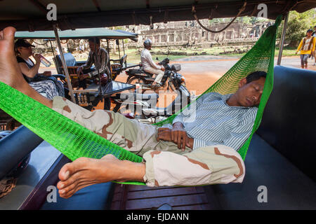 Cambodia, Siem Reap, Angkor Wat, Bayon Temple, Sleeping Tuk Tuk Driver Stock Photo