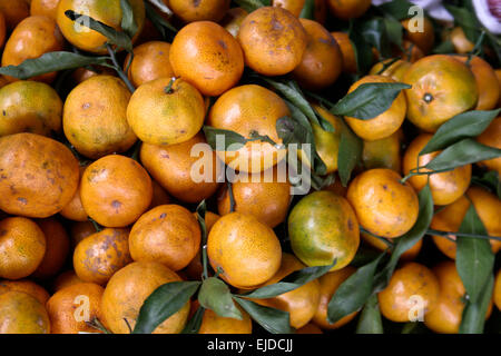 Piles of tangerines on display for sale in a market Stock Photo