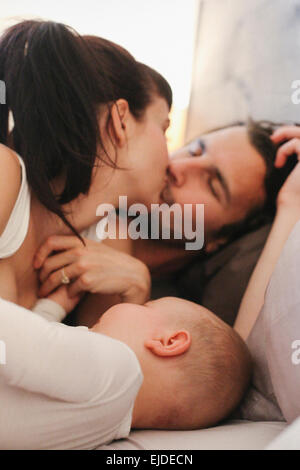 A mother, father and young baby playing at home. Stock Photo