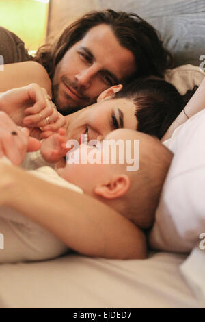 A mother, father and young baby playing at home. Stock Photo