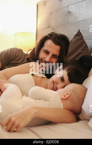 A mother, father and young baby playing at home. Stock Photo