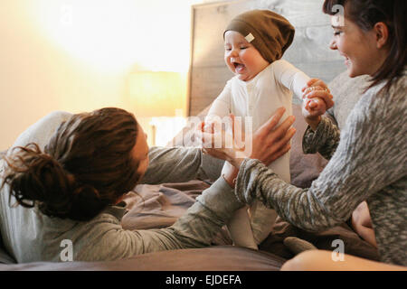A mother, father and young baby together at home. Stock Photo