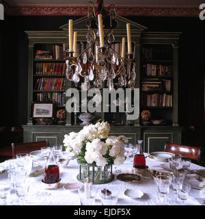 Antique crystal glass chandelier above table set for lunch in nineties dining room Stock Photo