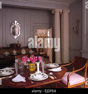 Classical columns in gray nineties dining room with table set for lunch Stock Photo