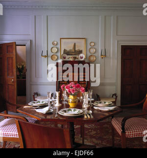 Table set for lunch in pale gray paneled nineties dining room Stock Photo