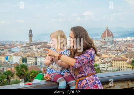 Happy mother pointing baby girl on copy space against panoramic view of florence, italy Stock Photo