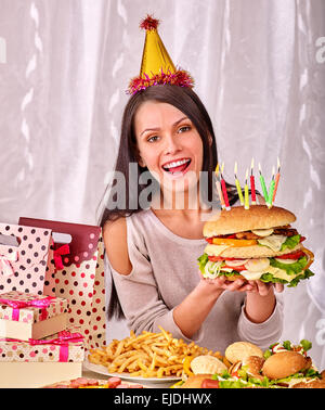 Woman eating hamburger at birthday. Stock Photo