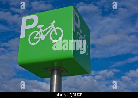 Green parking bicycle pole sign iver blue cloudy sky background Stock Photo