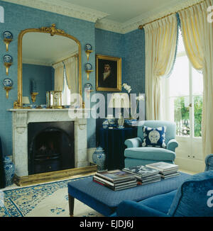 Large gilt mirror above marble fireplace in townhouse living room with ...