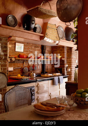 White double Aga in cottage kitchen with exposed brick wall Stock Photo