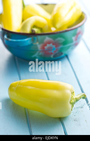 yellow peppers on blue table Stock Photo