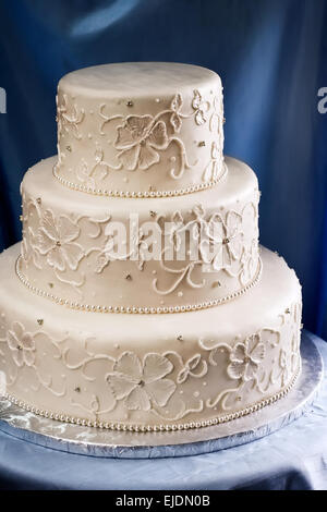 Three tiered wedding cake covered in ivory fondant with piped embroidery design Stock Photo