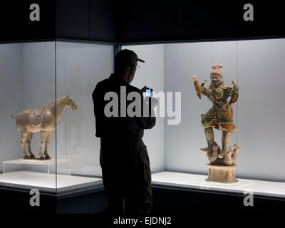 Tourist taking photos of a statue at the Gallery of Ancient Chinese Sculpture at the Shanghai Museum in Shanghai, China Stock Photo