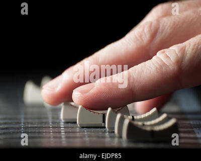 Hand moving  faders of the mixing desk, for music,sound,entertainment themes Stock Photo